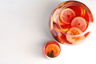 Photo of Tasty fruity punch on white table, top view with space for text. Refreshing drink
