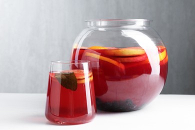 Photo of Tasty fruity punch on white table. Refreshing drink