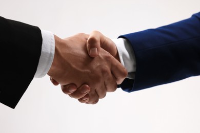 Photo of Business partners shaking hands on white background, closeup