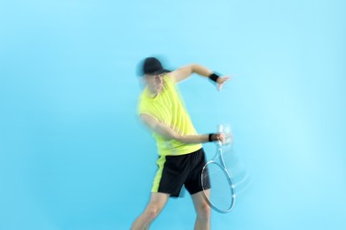Photo of Man with racket playing tennis on light blue background, motion blur effect