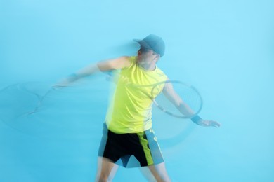Photo of Man with racket playing tennis on light blue background, motion blur effect