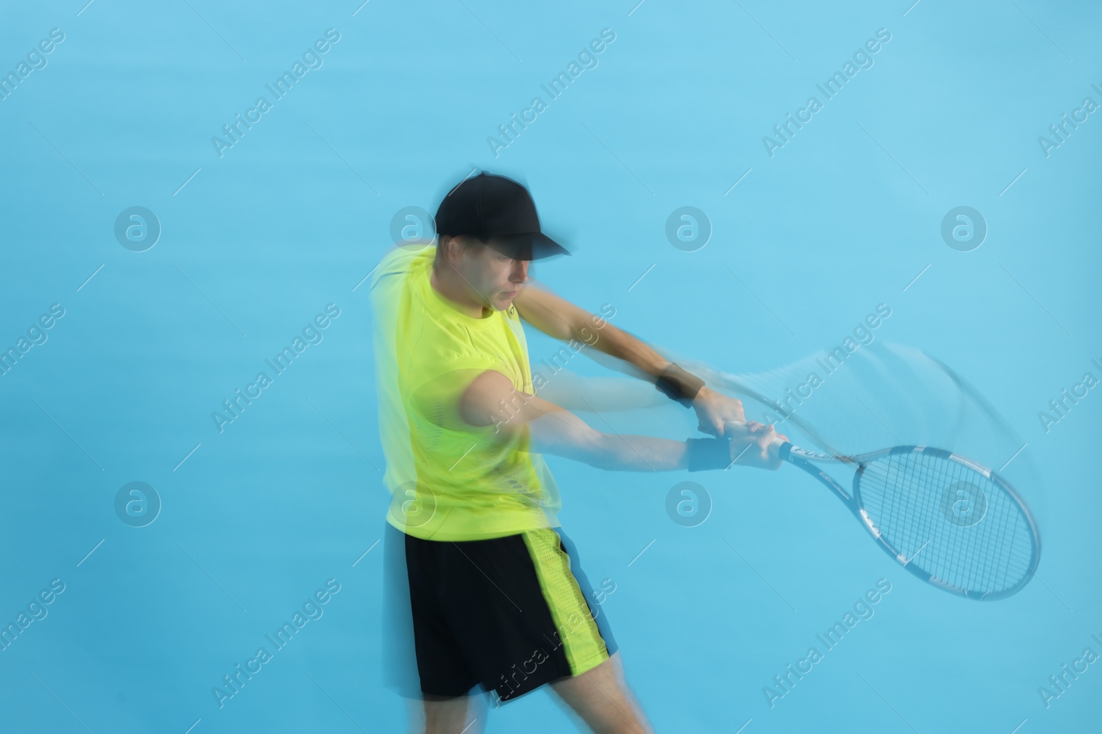 Man with racket playing tennis on light blue background, motion blur effect Photo of Man with racket playing tennis on light blue background, motion blur effect