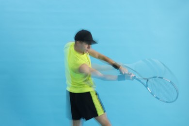 Photo of Man with racket playing tennis on light blue background, motion blur effect