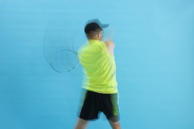 Photo of Man with racket playing tennis on light blue background, motion blur effect
