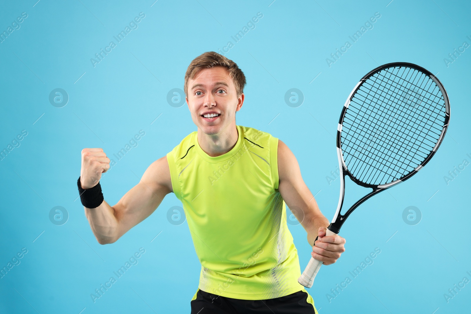 Man with tennis racket on light blue background Photo of Man with tennis racket on light blue background