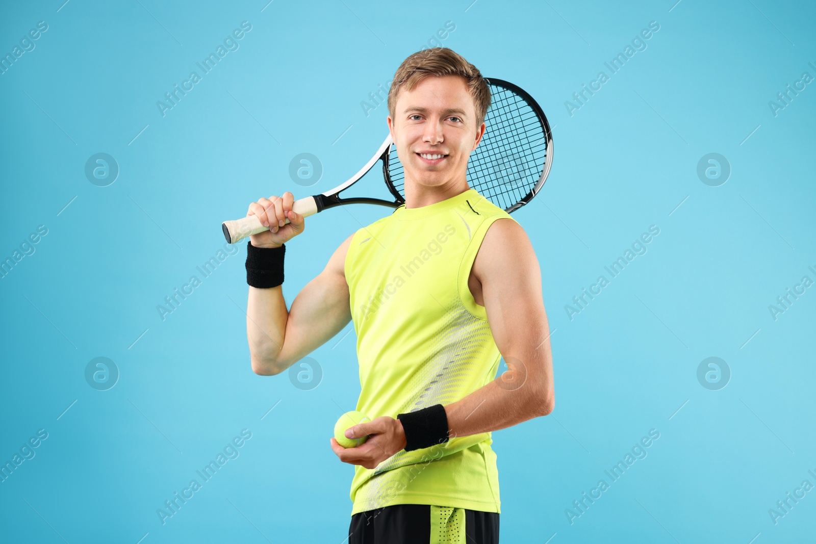 Man with tennis racket on light blue background Photo of Man with tennis racket on light blue background