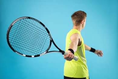 Photo of Man with tennis racket on light blue background