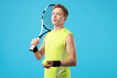 Photo of Man with tennis racket and ball on light blue background