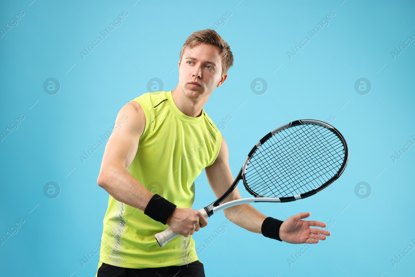 Man with tennis racket on light blue background Photo of Man with tennis racket on light blue background