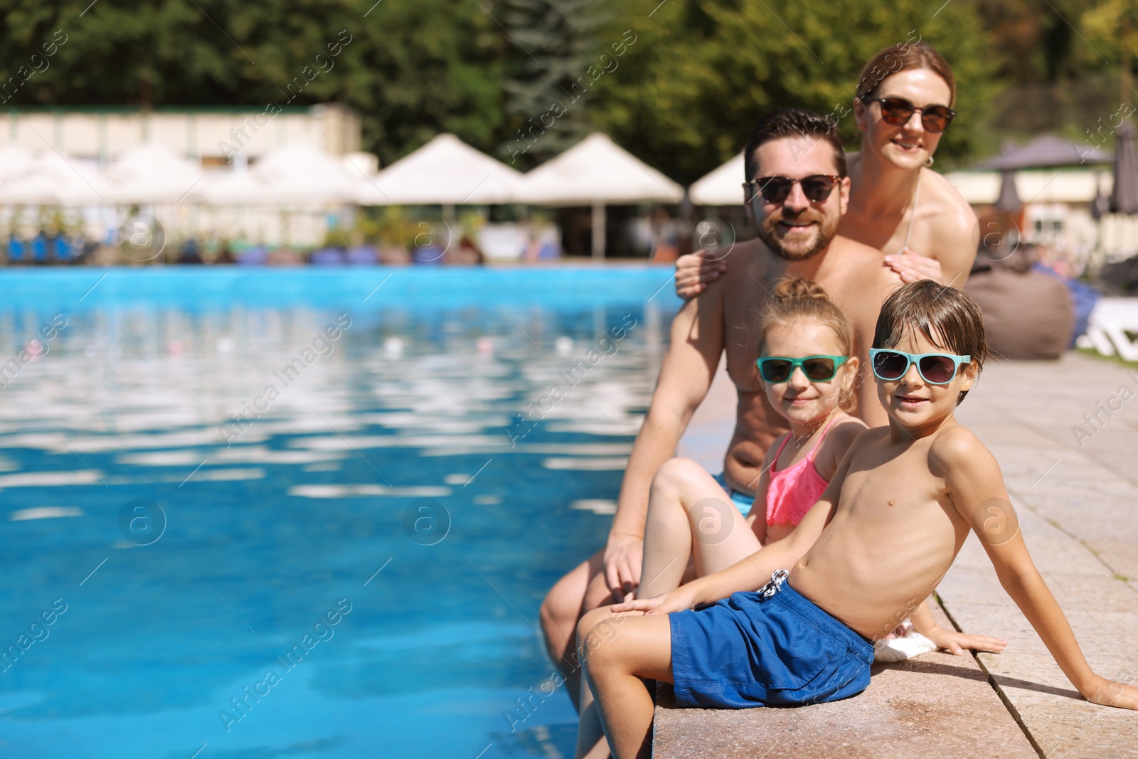 Happy family at poolside outdoors on sunny day, space for text Photo of Happy family at poolside outdoors on sunny day, space for text