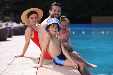 Photo of Happy family at poolside outdoors on sunny day
