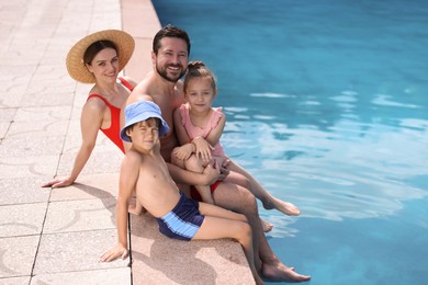 Photo of Happy family at poolside outdoors on sunny day, space for text