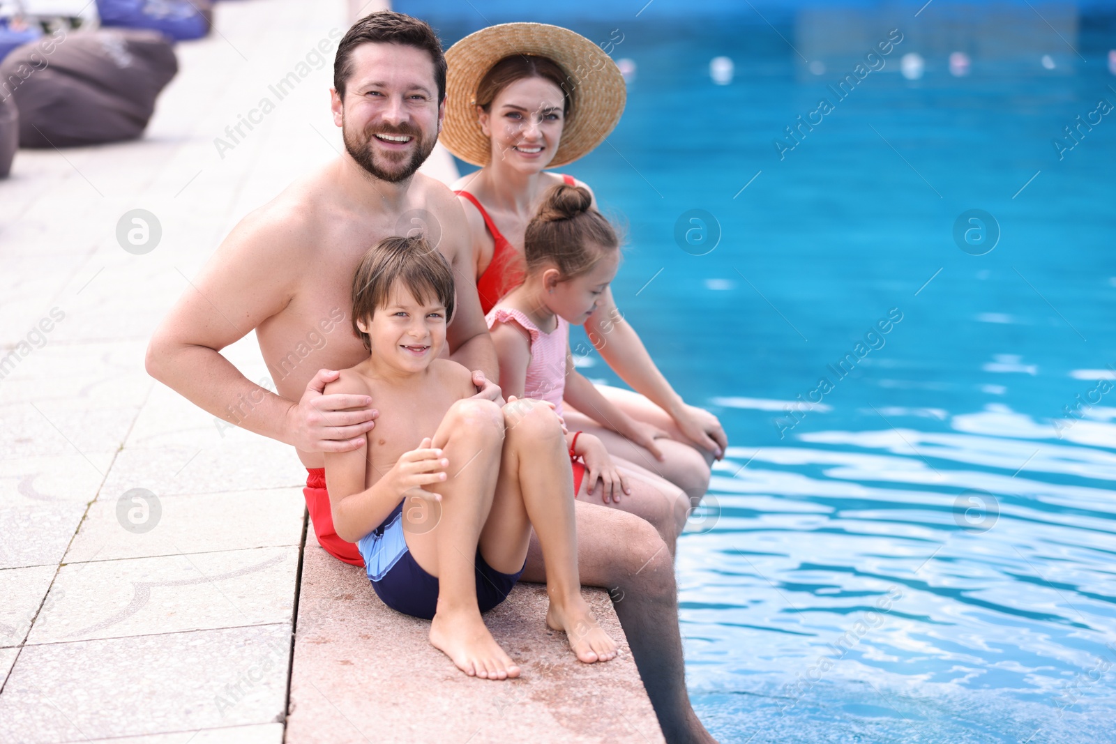 Photo of Happy family at poolside outdoors on sunny day