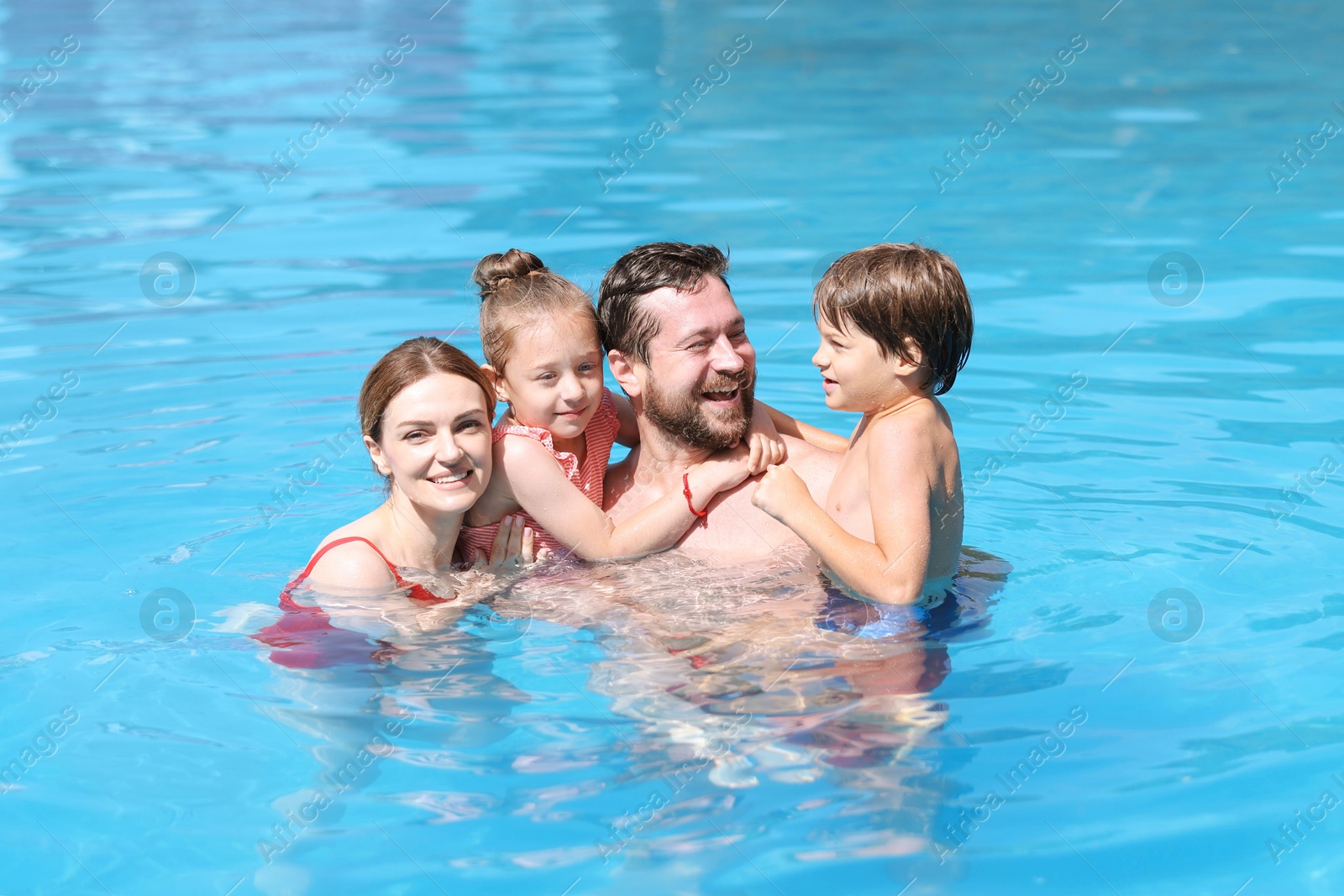 Happy family resting in swimming pool outdoors Photo of Happy family resting in swimming pool outdoors