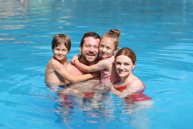 Photo of Happy family resting in swimming pool outdoors