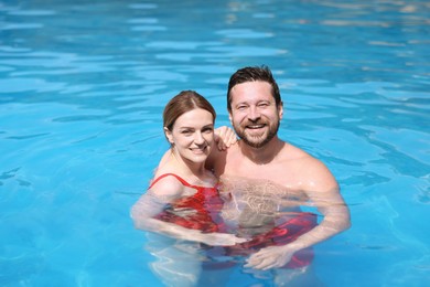 Photo of Happy couple resting in swimming pool outdoors. Family vacation