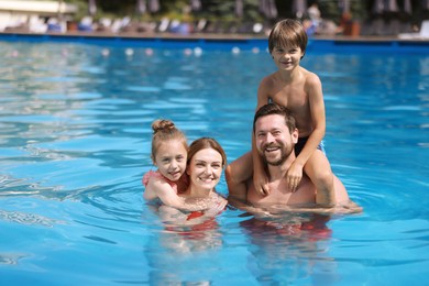 Photo of Happy family resting in swimming pool outdoors