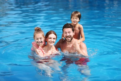 Photo of Happy family resting in swimming pool outdoors