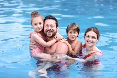Photo of Happy family resting in swimming pool outdoors