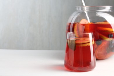 Photo of Tasty fruity punch on white table, space for text. Refreshing drink
