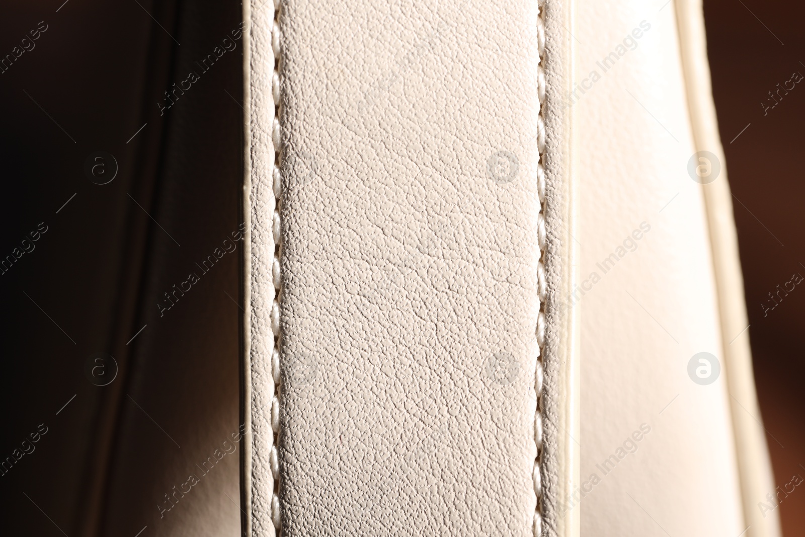 Photo of White leather bag on blurred background, closeup