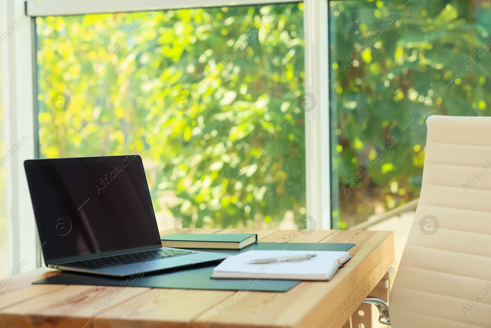 Photo of Home workplace. Laptop and stationery on wooden table