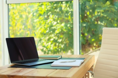 Photo of Home workplace. Laptop and stationery on wooden table