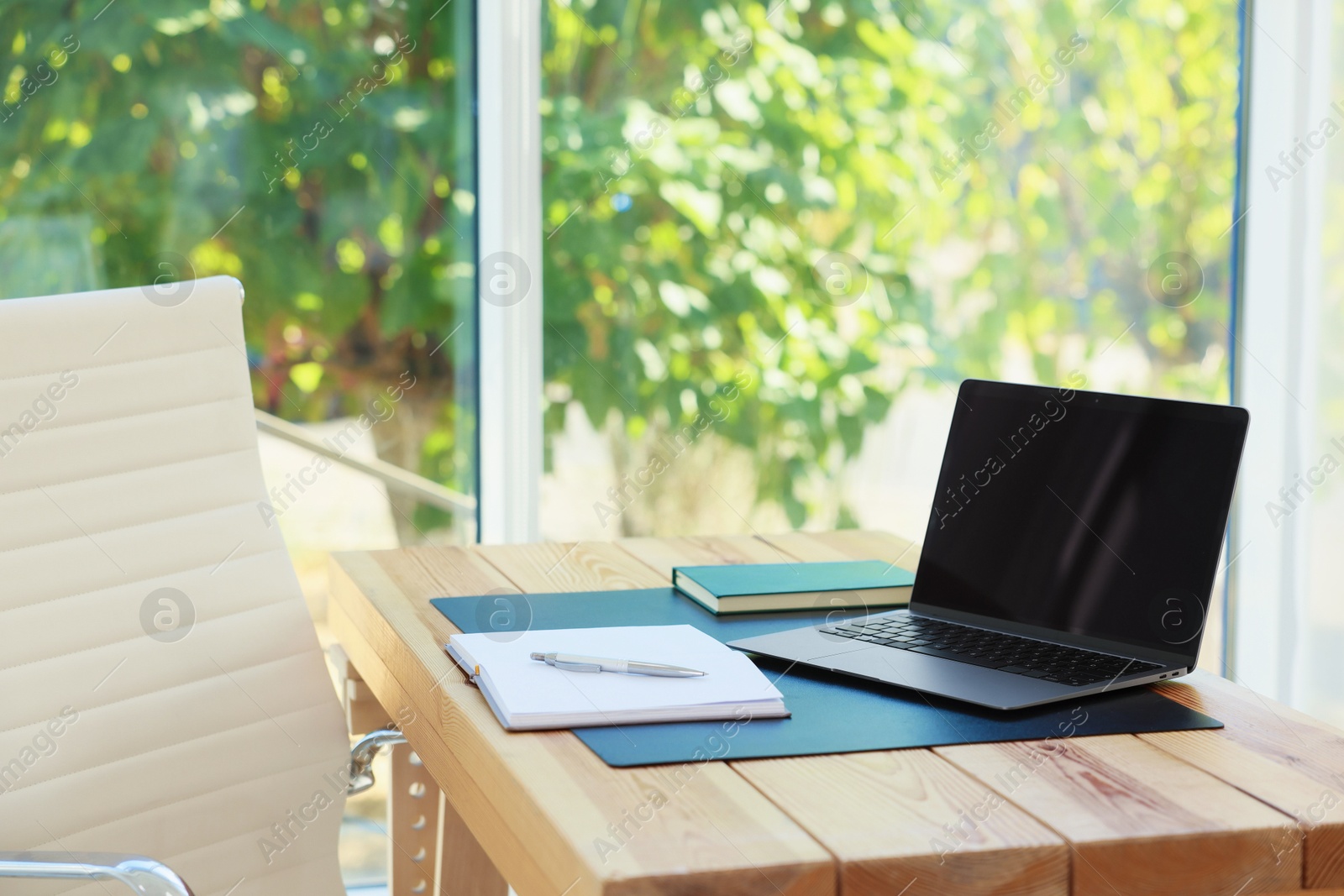 Photo of Home workplace. Laptop and stationery on wooden table