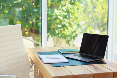Photo of Home workplace. Laptop and stationery on wooden table