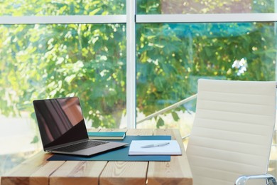 Photo of Home workplace. Laptop and stationery on wooden table