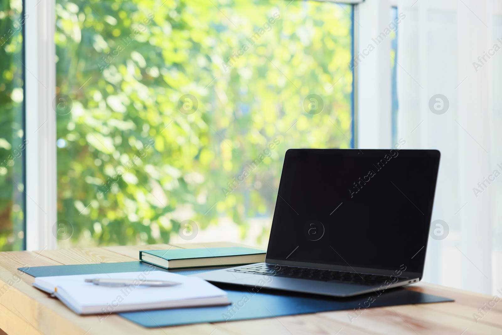 Photo of Home workplace. Laptop and stationery on wooden table