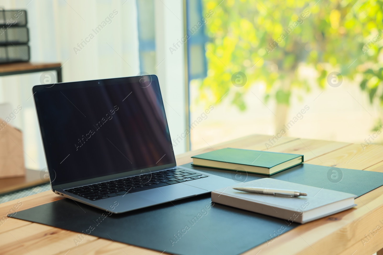 Photo of Home workplace. Laptop and stationery on wooden table