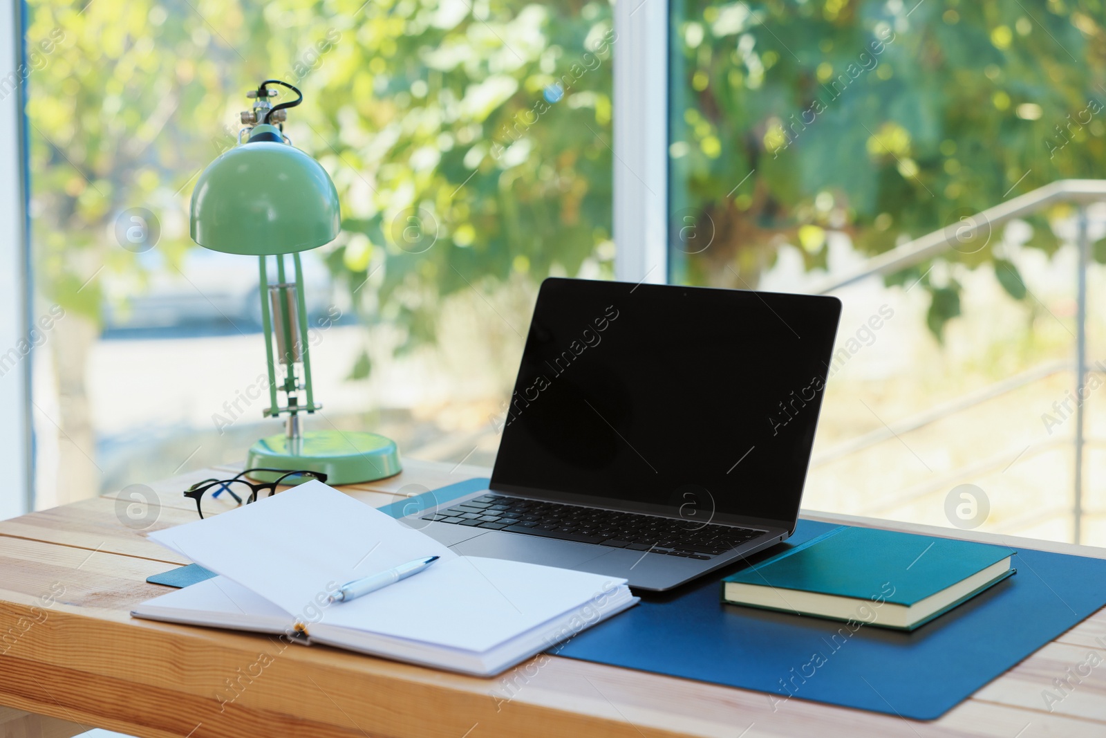 Photo of Home workplace. Laptop and stationery on wooden table