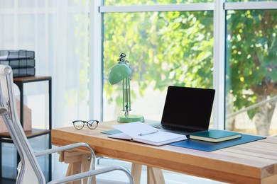 Photo of Home workplace. Laptop and stationery on wooden table