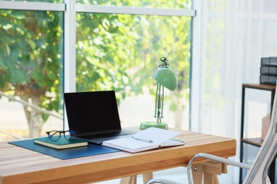 Photo of Home workplace. Laptop and stationery on wooden table