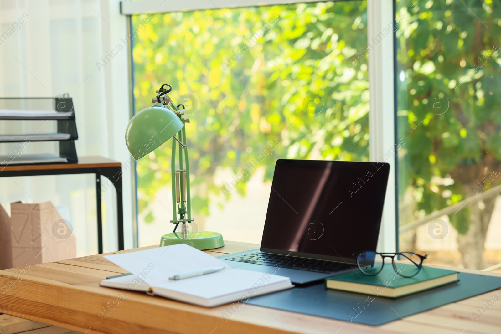 Photo of Home workplace. Laptop and stationery on wooden table