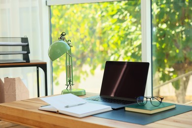 Photo of Home workplace. Laptop and stationery on wooden table