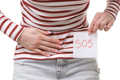 Photo of Woman holding sticky note with word SOS and suffering from cystitis symptoms on white background, closeup