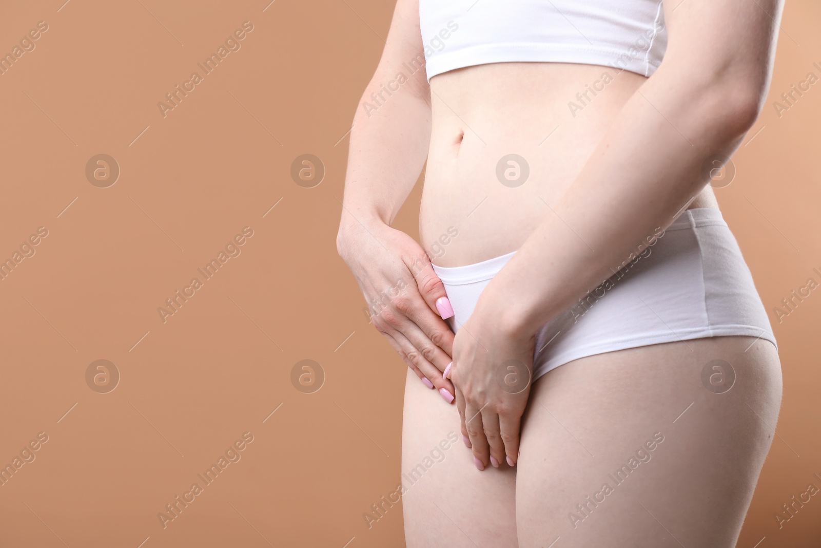 Photo of Woman suffering from cystitis symptoms on dark beige background, closeup. Space for text