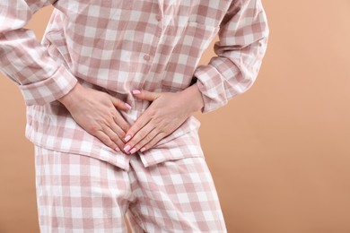 Photo of Woman suffering from cystitis symptoms on dark beige background, closeup. Space for text