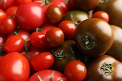 Photo of Different ripe juicy tomatoes as background, closeup