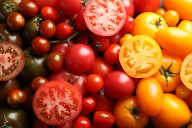 Photo of Different ripe juicy tomatoes as background, closeup