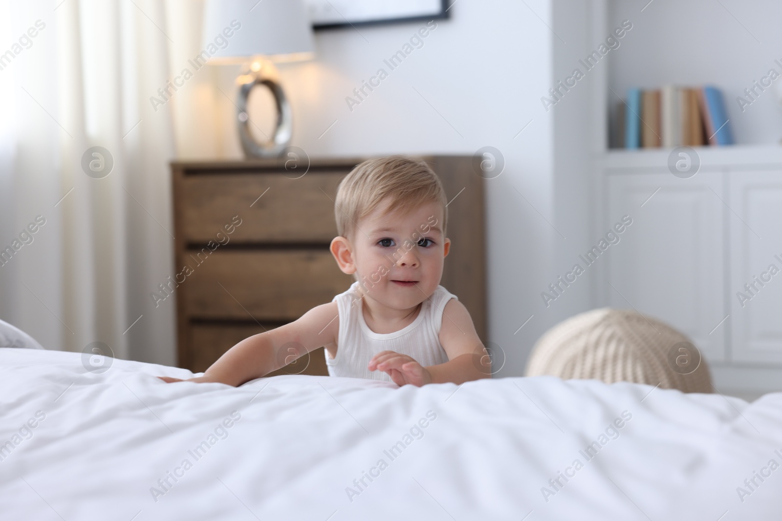 Cute little baby near bed at home Photo of Cute little baby near bed at home