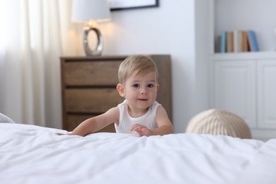 Photo of Cute little baby near bed at home
