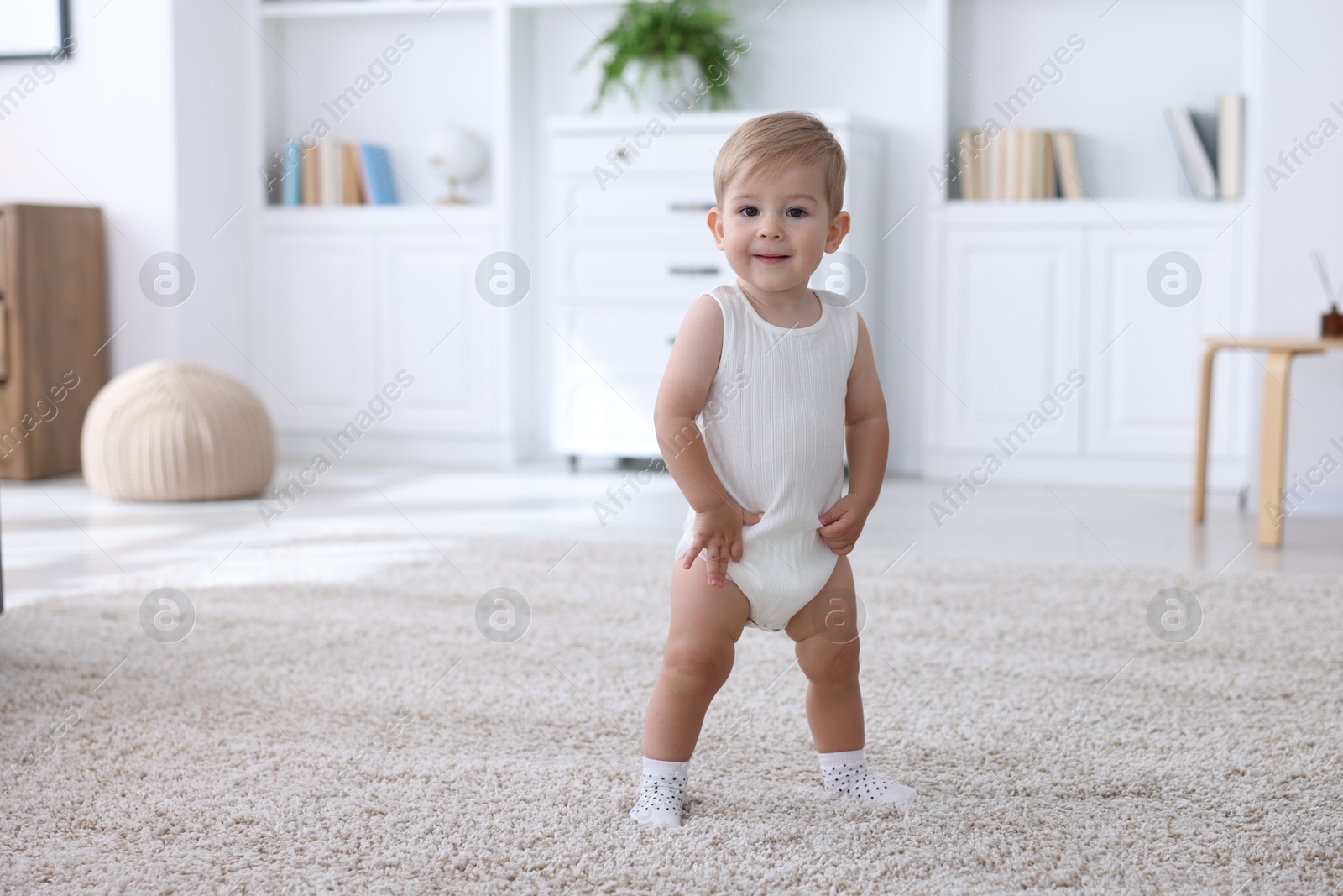 Cute little baby in onesie at home, space for text Photo of Cute little baby in onesie at home, space for text