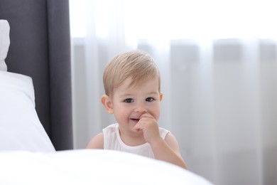 Photo of Cute little baby near bed at home