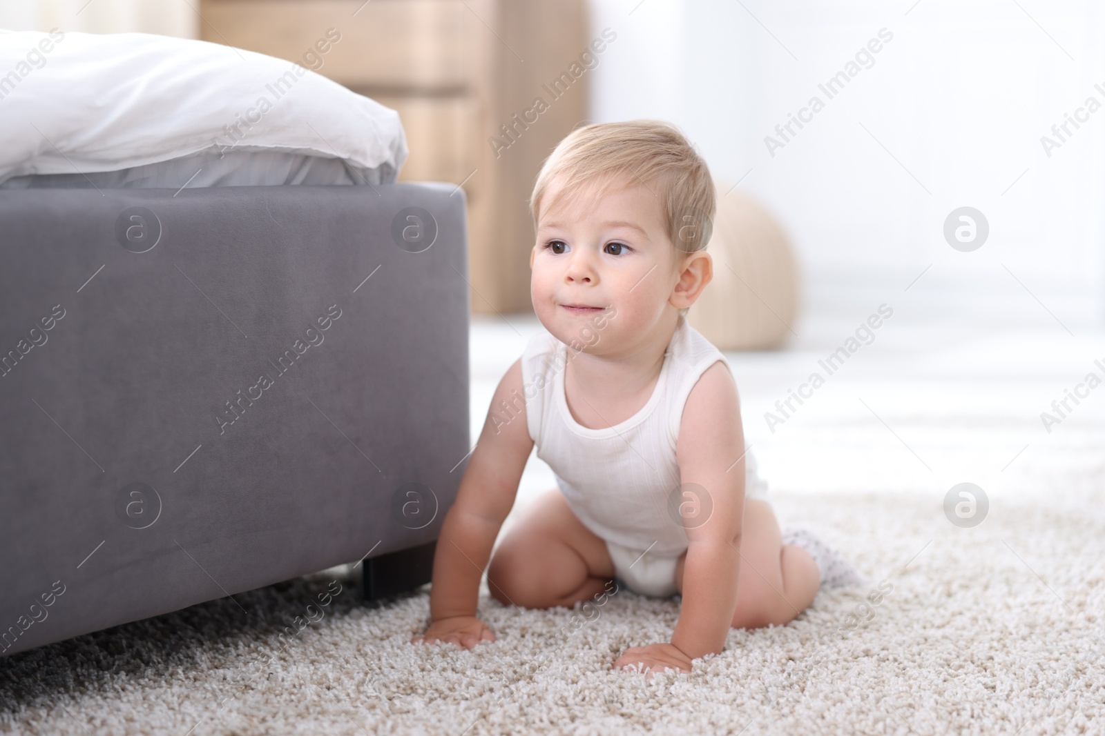 Cute little baby near bed at home Photo of Cute little baby near bed at home