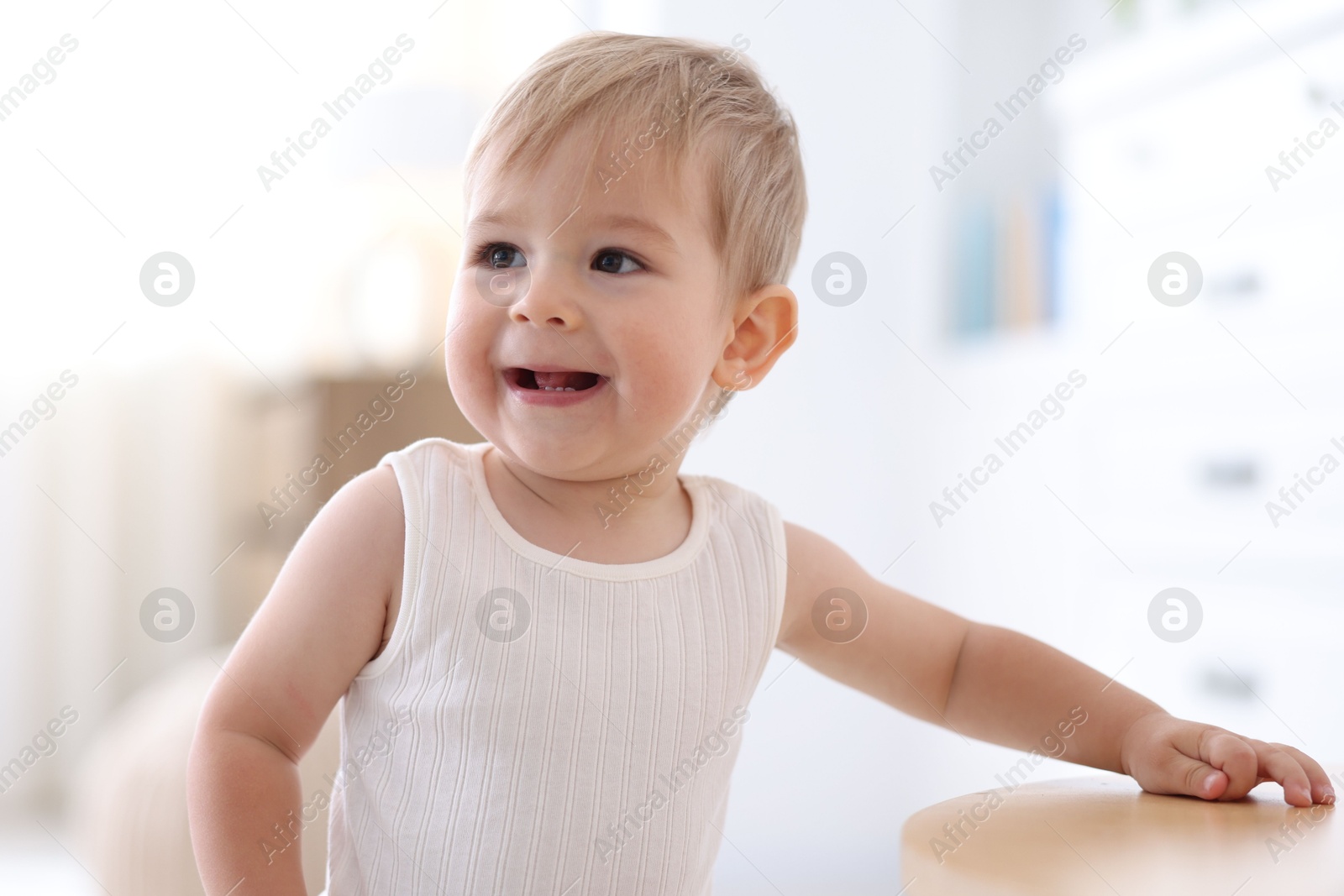 Photo of Cute little baby near table at home
