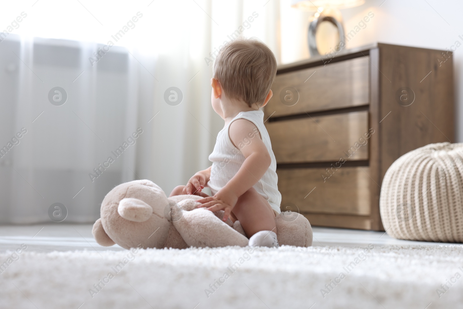 Photo of Cute little baby with toy on floor at home
