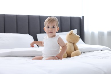 Photo of Cute little baby and toy on bed at home